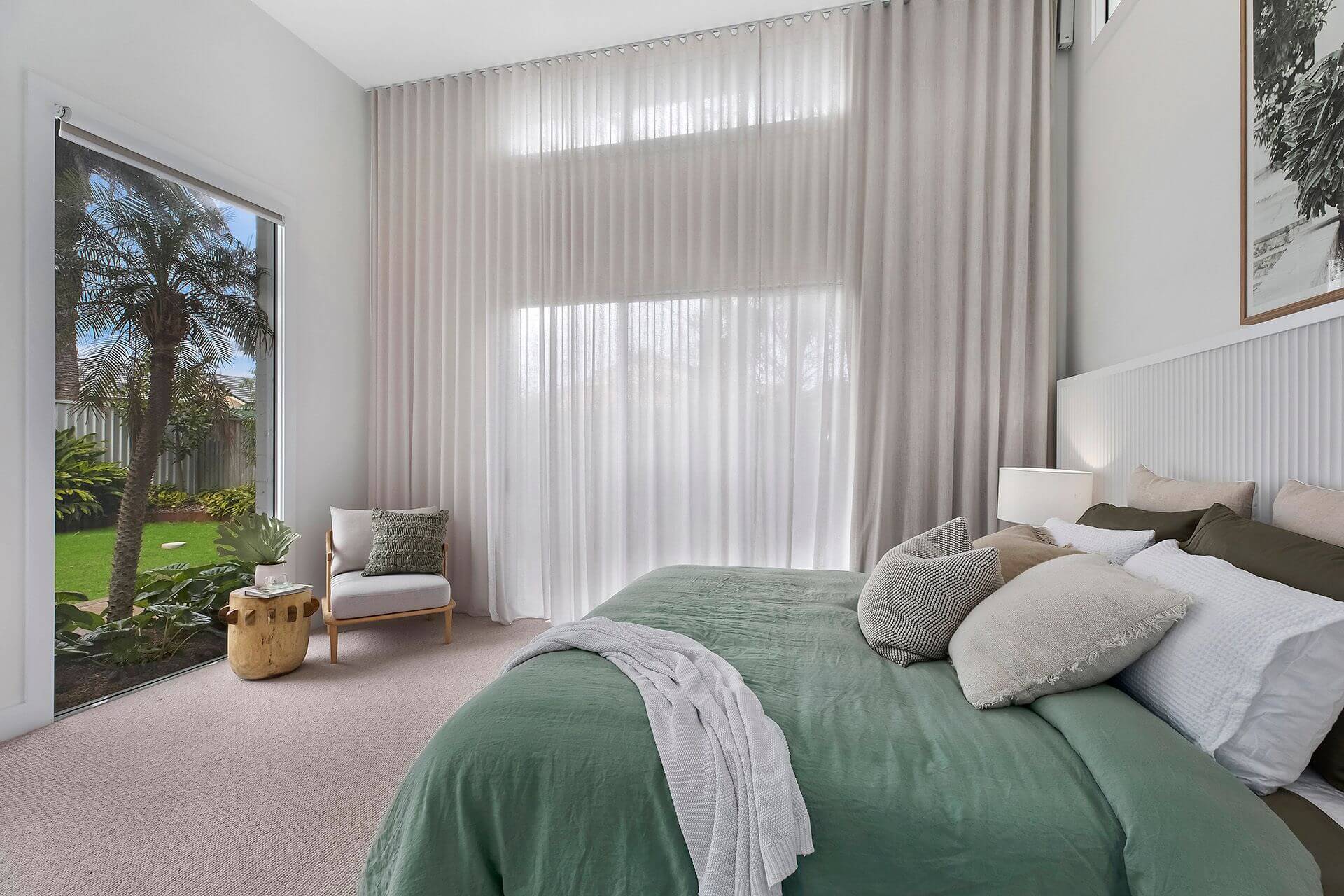 Modern bedroom with large window at far wall with views of garden
